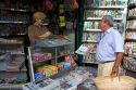 French man purchasing a newspaper from a Presse news kiosk in Sanary-sur-Mer, France.
