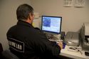 Fingerprint analyst using a computer to classify fingerprints in a crime laboratory.