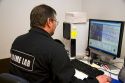 Fingerprint analyst using a computer to classify fingerprints in a crime laboratory.