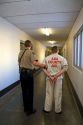 Handcuffed inmate being escorted to a holding cell in a jail.