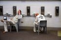 Inmates talk on telephones in the day use area of a county jail.