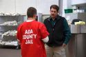 Guard and inmate interact in the day use area of a county jail.