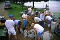 Adult and children volunteers sandbagging for a flooded Mississippi River in Prineton, Iowa, USA.