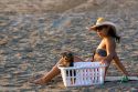 Woman relaxing on the beach with a small dog at Playa Carrillo near Samara, Costa Rica.