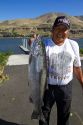 Native American indian displaying a chinook salmon on the Columbia River, Oregon, USA.