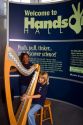 Child playing an electronic stringless harp at the Gulf Coast Exploreum Science Center in Mobile, Alabama, USA.