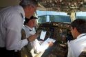 Pilot and first officer reviewing a pre-flight checklist in the cockpit of a Boeing 767 aircraft.