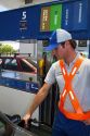 Gas station attendent fueling an automobile in Argentina.