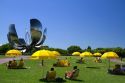 People sit under yellow umbrellas near the Floralis Generica sculpture located in Plaza de las Naciones Unidas in Buenos Aires, Argentina.
