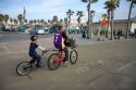 Kids ride bicycles at Mission Beach, San Diego, California, USA.