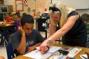 Female teacher helping students in a fourh grade classroom at a public elementary school in Brandon, Florida, USA.