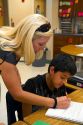 Female teacher helping students in a fourh grade classroom at a public elementary school in Brandon, Florida, USA.