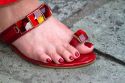 Woman wearing a red jeweled sandal at the Temple of the Emerald Buddha located within the precincts of the Grand Palace, Bangkok, Thailand.