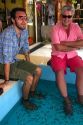 Men enjoy a foot pedicure given by doctor fish on the island of Ko Samui, Thailand.