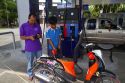 Gas station attendent filling up a motor scooter on the island of Ko Samui, Thailand.
