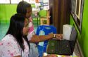 Thai elementary school student and teacher use a laptop computer on the island of Ko Samui, Thailand.