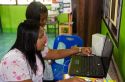 Thai elementary school student and teacher use a laptop computer on the island of Ko Samui, Thailand.