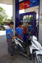 Gas station attendent filling up a motor scooter on the island of Ko Samui, Thailand.
