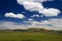 Cumulus clouds and blue sky over green fields near Pine, Idaho, USA.