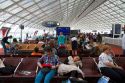 Travelers in a waiting room at Charles de Gaulle Airport, Paris, France.