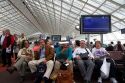 Travelers in a waiting room at Charles de Gaulle Airport, Paris, France.