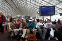 Travelers in a waiting room at Charles de Gaulle Airport, Paris, France.