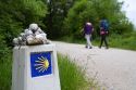 Pilgrims walk near a marker along the Camino De Santiago, the Way of St. James pilgrimage route, Navarra, Spain.