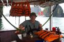 American tourist captoning a tour boat in Ha Long Bay, Vietnam.