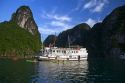 Tour boat and tourists using sea kayaks in Ha Long Bay, Vietnam.