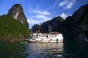 Tour boat and tourists using sea kayaks in Ha Long Bay, Vietnam.