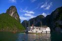 Tour boat and tourists using sea kayaks in Ha Long Bay, Vietnam.