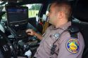 Florida state trooper using computer in patrol car.