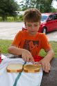 Ten year old boy making a peanut butter sandwich.