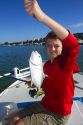 11 year old boy holding up his catch of a Jack Cravalle saltwater fish in Florida, USA. MR