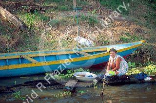 Brazillian woman washing clothes in the Amazon River in Manaus Brazil.