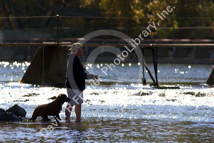A man and his dog fly fishing on the Payette River in Idaho.
