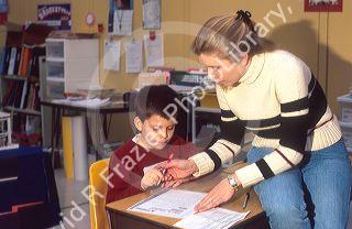 Elementary school teacher helping a student in her classroom.  MR
