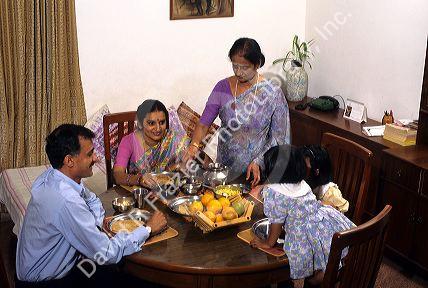 A middle class Indian family is sewrved a meal by grandmother at home in Bangalore, India.