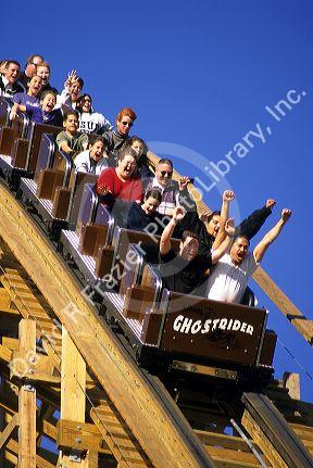 People riding the Ghostrider roller coaster at Knotts Berry Farm, California.