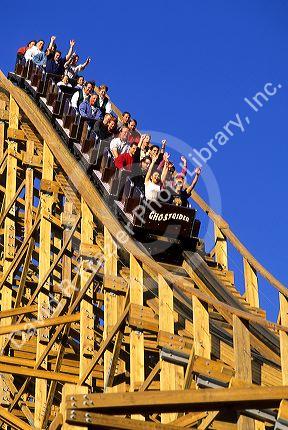 People riding the Ghostrider roller coaster at Knotts Berry Farm, California.