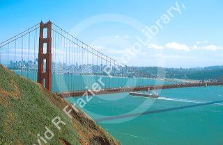 Cargo ship passing beneath The Golden Gate Bridge in San Francisco, California.