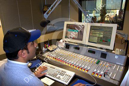 Sound engineer operating commercial broadcast radio control panel in Boise, Idaho. MR