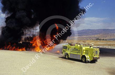 An airport crash response truck putting out a training fire.