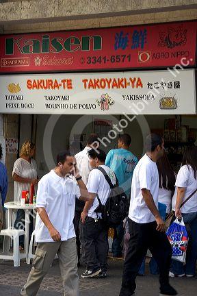 People passing in front of a Japanese store in the Liberdade asian section of Sao Paulo, Brazil.