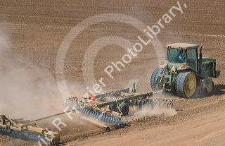 Crawler type tractor discing a field in preparation for planting in the Central Valley of California.
