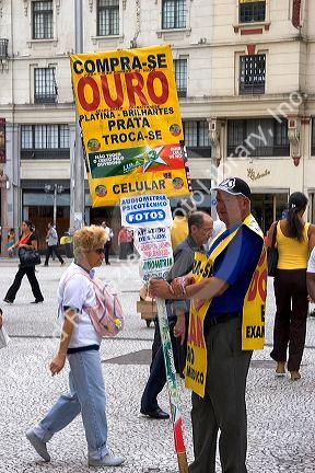 Man holding a sign advertising for a jewelry store in Sao Paulo, Brazil.