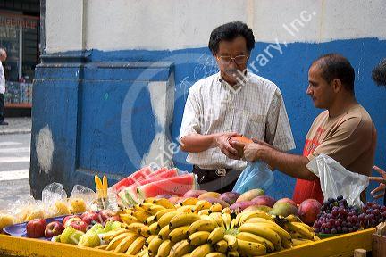 Man shopping at a fruit stand in Sao Paulo, Brazil.