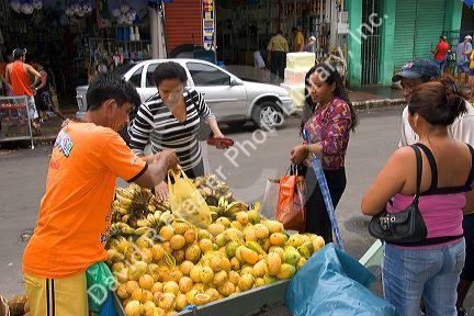 People buying fruit from a street vendor in Manaus, Brazil.