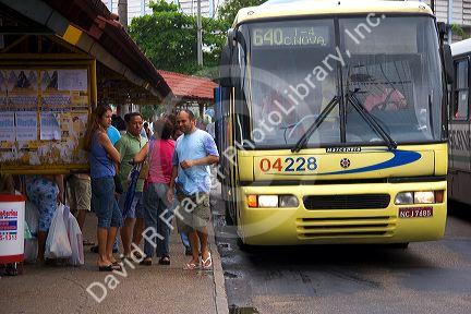 People wait at a bus stop in Manaus, Brazil.