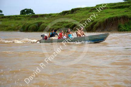 Brazilian people ride in a small river boat on the Amazon River near Manaus, Brazil.
